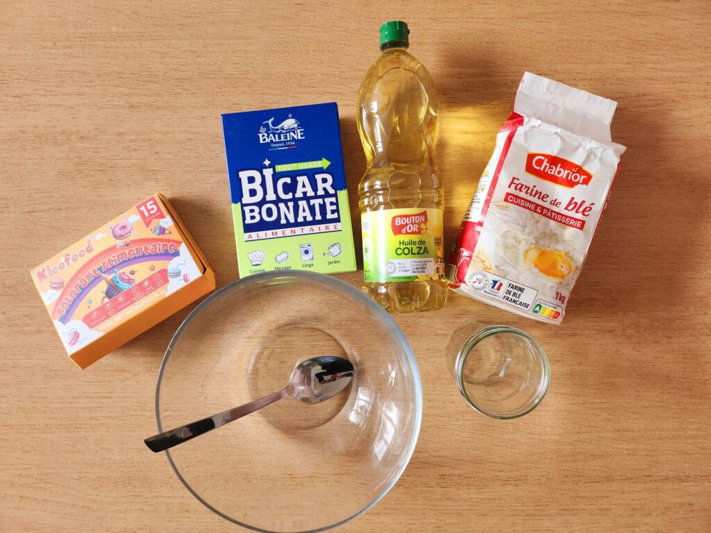 Ingrédients nécessaires pour fabriquer du sable magique maison : farine, bicarbonate, huile, colorant alimentaire